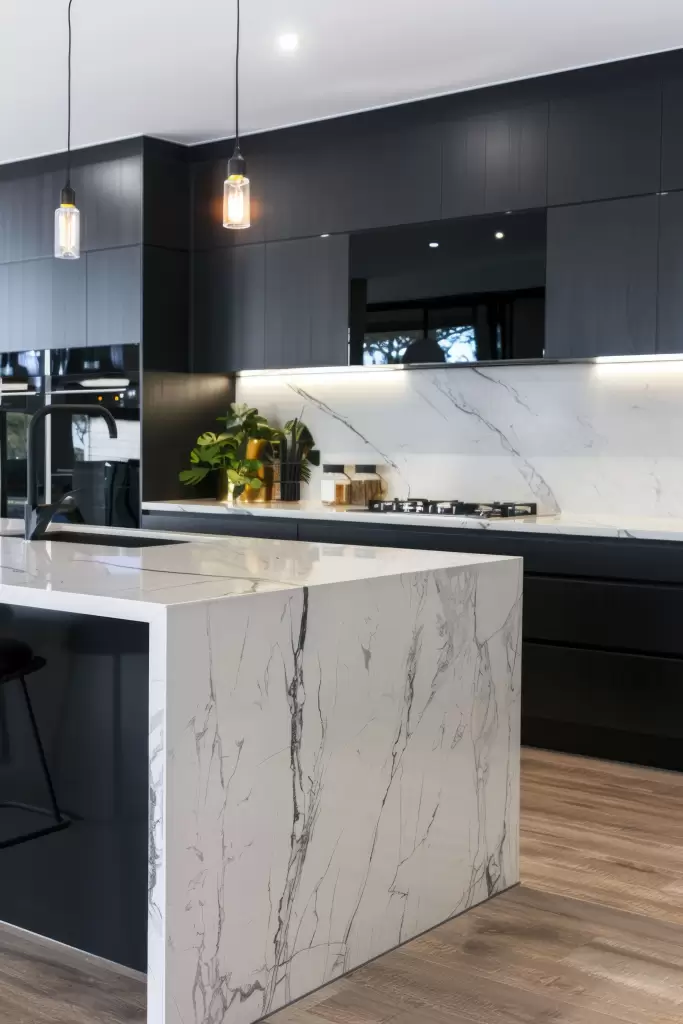 Cozinha moderna com móveis planejados, ilha central e iluminação sofisticada.